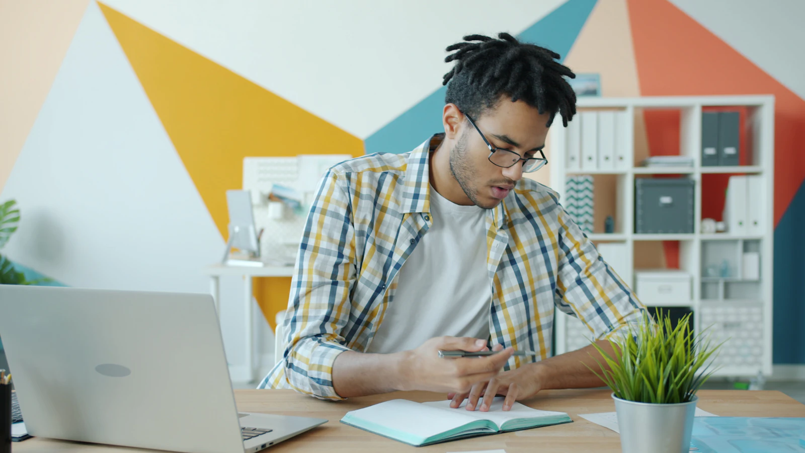 A professional checks an appointment notebook at his desk