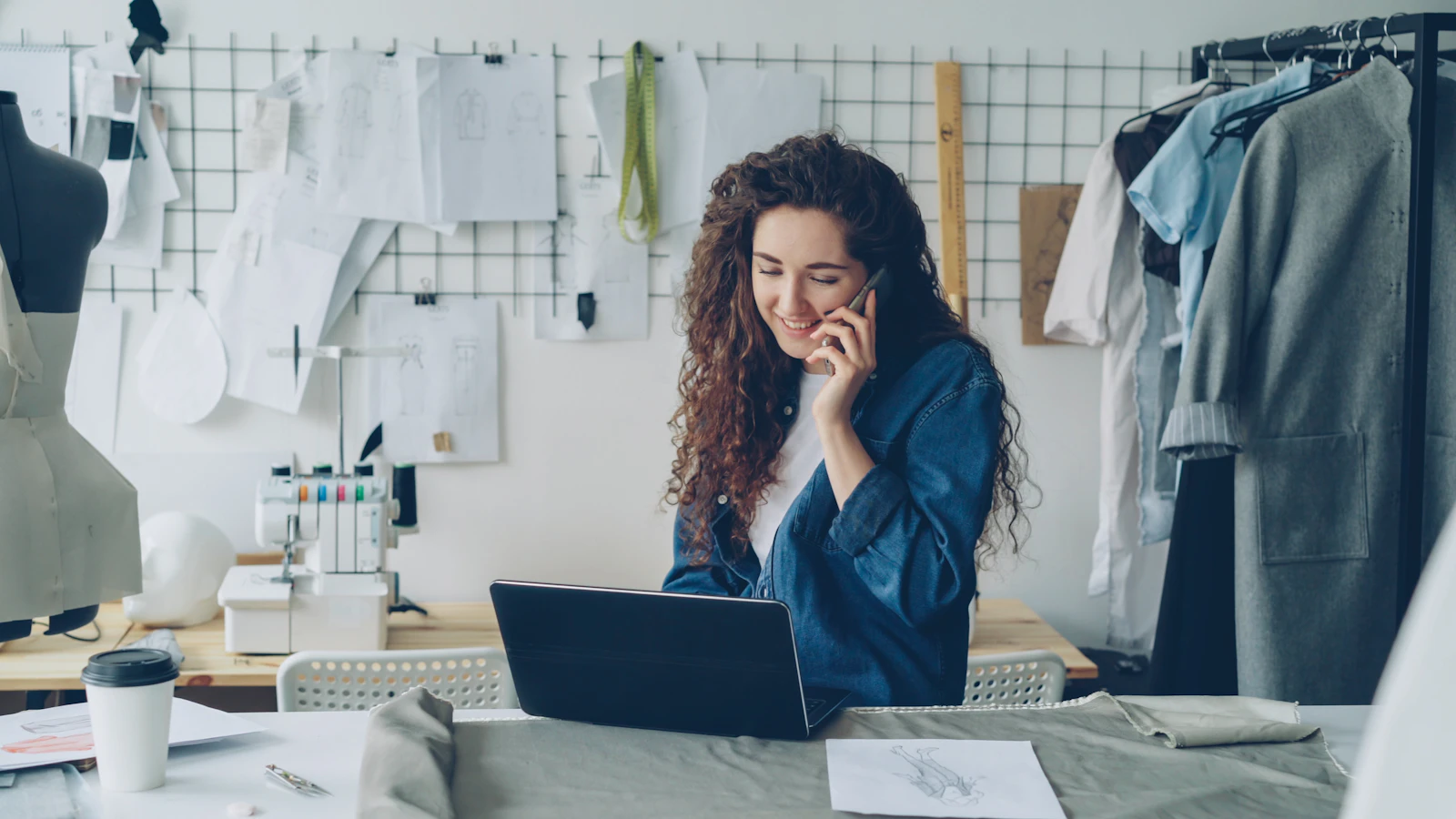 A shop owner works on her computer in a fashion studio